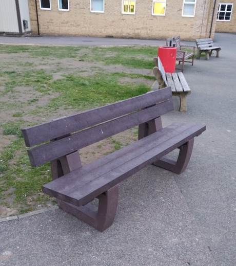 A recycled plastic bench in the grounds of Dartford Grammar School, with an older concrete bench behind.