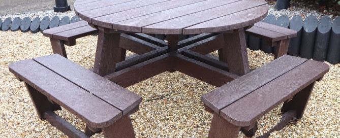 A brown circular Calder picnic table made from recycled plastic and guaranteed for 25 years.