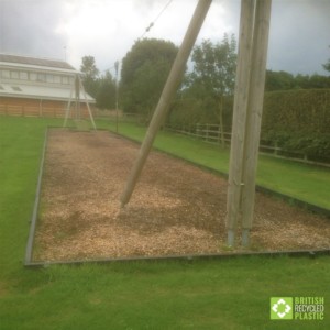 Recycled plastic lumber planks used to retain woodchip in a zipline pit.