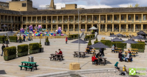 Various Denholme picnic tables at The Piece Hall, with visitors 02