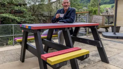 Man enjoying coffee at colourful Bradshaw British Recycled Plastic table
