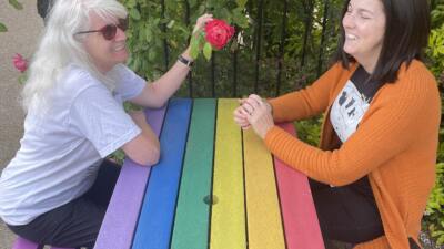 Two women at a rainbow table. Bradshaw picnic table