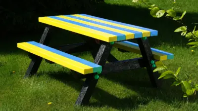 Colourful picnic table on green grass. British Recycled Plastic