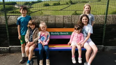 Children sitting on a colourful bench. british recycled plastic