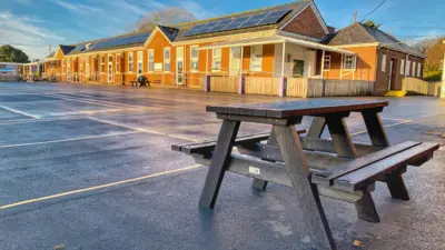 Picnic table outside school building. British Recycled Plastic