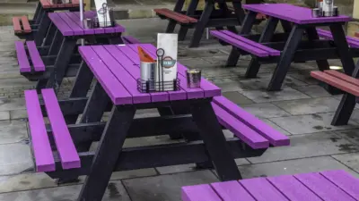 Recycled plastic picnic tables in piece hall courtyard. Pink