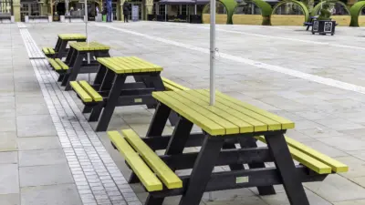 Recycled plastic picnic tables in piece hall courtyard. Yellow