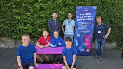 Kent county council and 'Recycle Your Electricals' Campaign. Group promoting electrical recycling initiative sitting at a pink Holmfirth British Recycled plastic picnic table