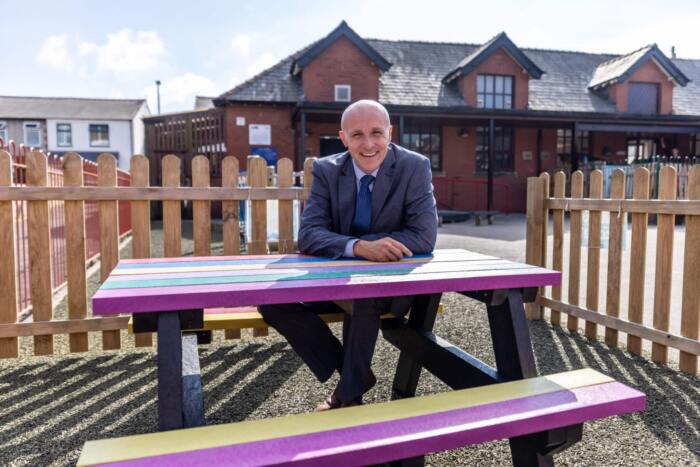 Holmfirth picnic table at Kirkham and Wesham Primary School - with headteacher Lee Glynn (1) Holmfirth picnic table with a smiling teacher