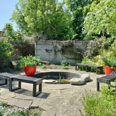 Garden seating area with planters. British Recycled Plastic Skipton Curve Benches