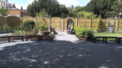 Serene garden with curved wooden benches. British Recycled Plastic