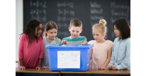 Teaching sustainability to kids in a classroom with recycling bins