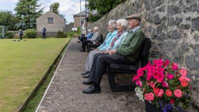people at a sports club watching the game sat on a British Recycled Plastic Harewood Bench