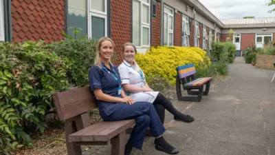 Two nurses sitting on benches outside. British Recycled Plastic