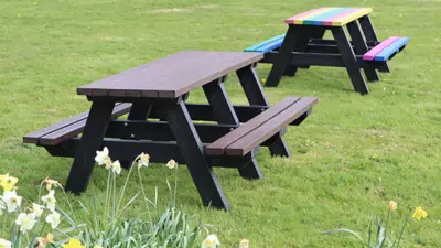 Two picnic tables on grassy area. British Recycled Plastic