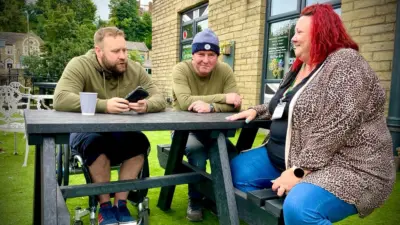 Three people chatting at a table. Bradshaw picnic table