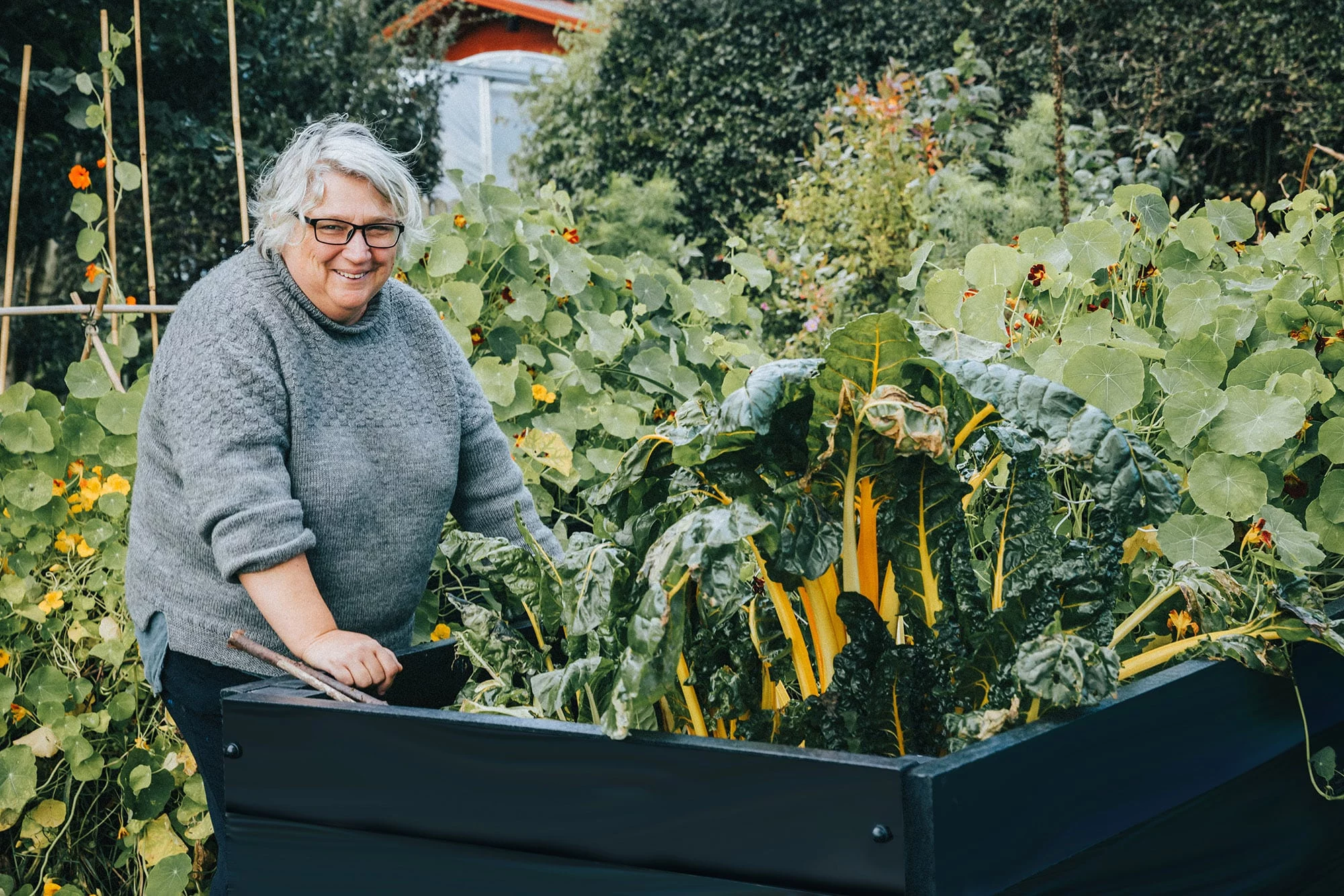 Hannah leaning on a 750mm high recycled plastic raised bed. Perfect for anyone who doesn't want to bend down too much.