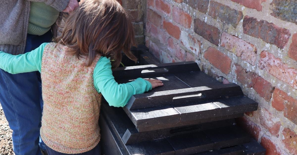 A child looking in a Micro Callis recycled plastic compost bin