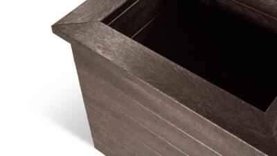 A corner detail of a Haworth recycled plastic planter in brown