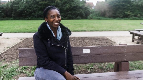 Sherel Rutherford, a British Recycled Plastic customer service manager, on a brown recycled plastic Harewood memorial bench in Driffield, East Yorkshire