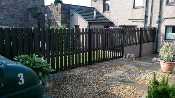 Recycled plastic pallisade fencing in a garden in Cumbria