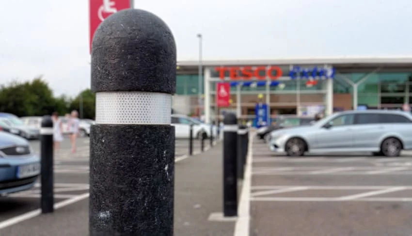 Halifax recycled plastic bollards in a Tesco car park in the classic "Tesco configuration" of dome top and 50mm white reflective strip.