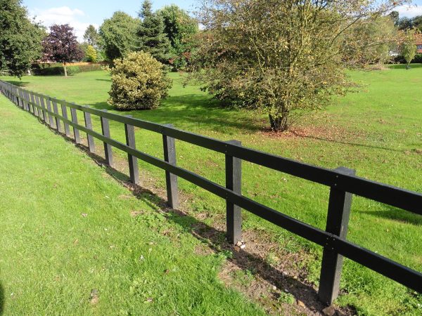 Recycled plastic lumber planks and posts used to make a post-and-rail fence for a village green in Yorkshire