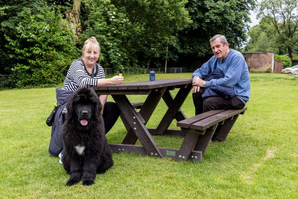 Recycled plastic Batley picnic table with couple and Newfie at Moss Bank Park, Bolton