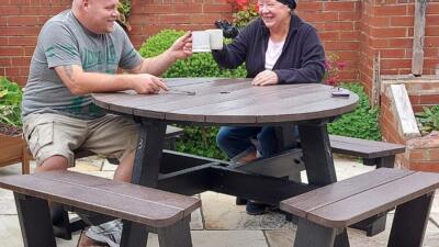 After assembling their recycled plastic Calder picnic table, the workers pause for a well-earned brew