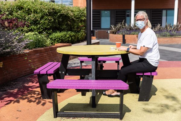 A Pink and yellow Calder 8 seater recycled plastic picnic table at Sheffield Children's Hospital