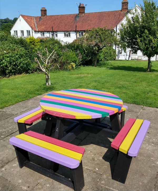 A rainbow coloured Calder picnic table engineered from British Recycled Plastic at Kilburn Chicken Cottage