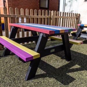 The Holmfirth junior recycled plastic A-frame picnic table with rainbow tops and seats at Kirkham and Wesham Primary School, suitable for infant and junior schools