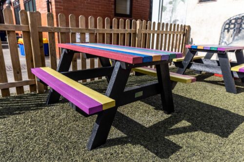 The Holmfirth junior recycled plastic A-frame picnic table with rainbow tops and seats at Kirkham and Wesham Primary School, suitable for infant and junior schools
