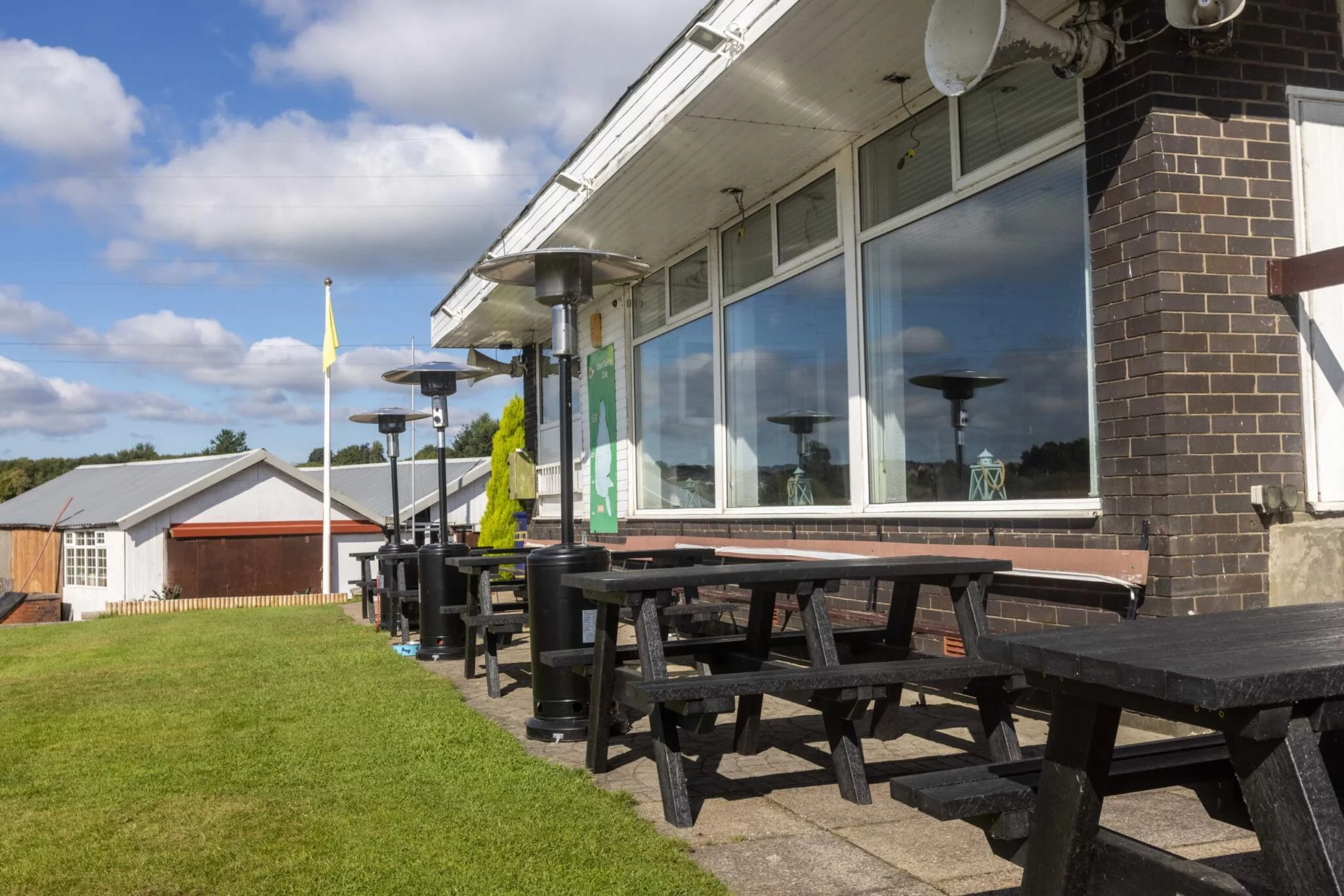 Denholnme black picnic benches at a golf club