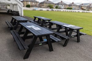 Denholnme black picnic benches at a cricket club