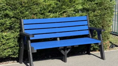 Bright blue bench by green hedge. Ilkley bench by British Recycled Plastic