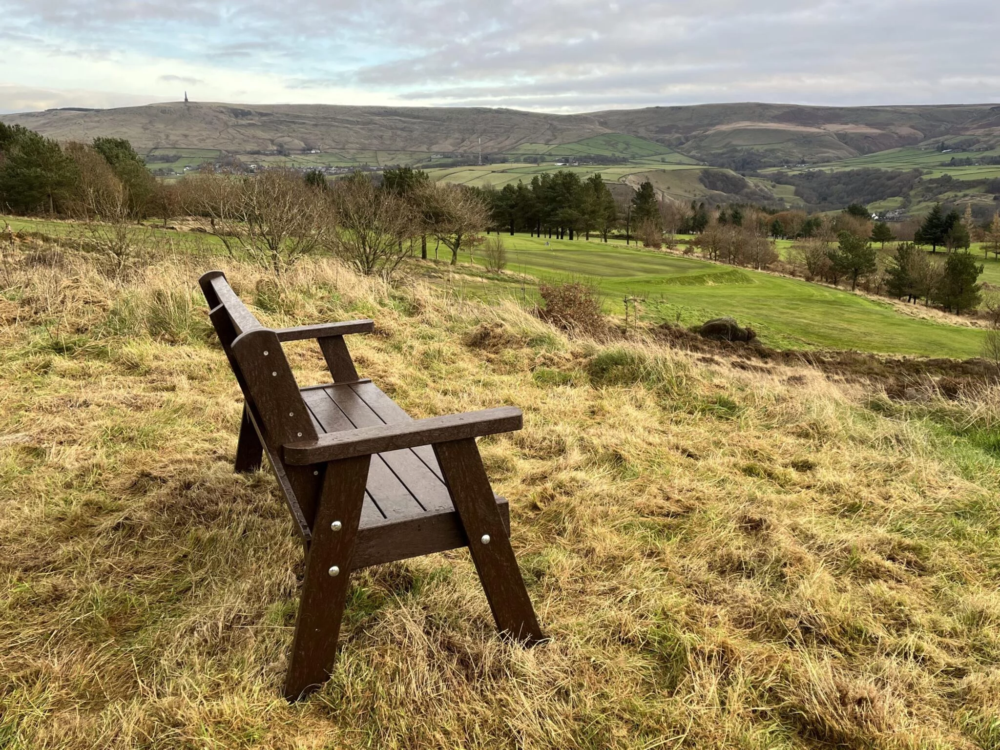 An Ilkley recycled plastic brown bench. Placed over looking the Calder valley.