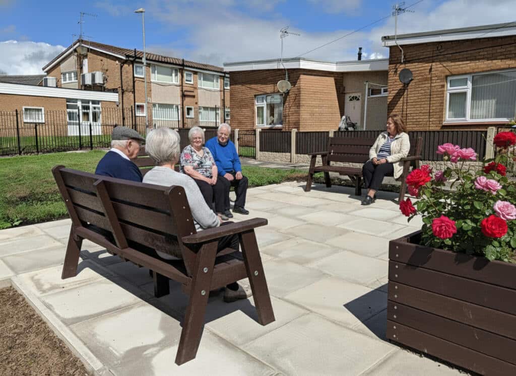 Residents enjoying time in communal garden at British Recycled Plastic Ilkley Bench