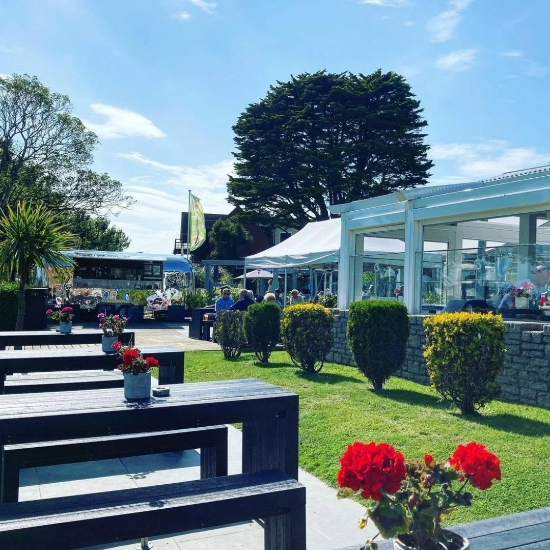 grey recycled plastic benches and tables next to a law in a hospitality venue