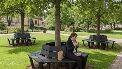 Woman enjoying lunch on calverley hexaganol tree bench.