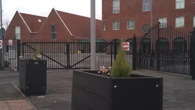 Planters beside a signpost and gate. British Recycled Plastic Planter
