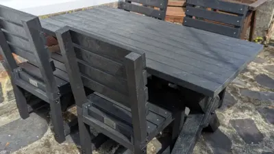 Black dining set outdoors on a solid floor. 4 chairs. British Recycled Plastic