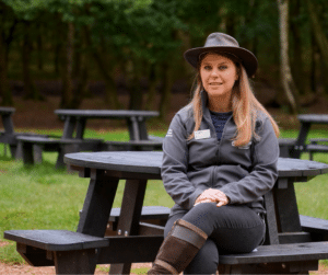 RSBP Sherwood Forest site manager sitting on recycled plastic Calder picnic tables with wheelchair accessibility, purchased to create an inclusive environment and increase footfall by catering to a wider and more diverse audience. Accessibility in outdoor spaces