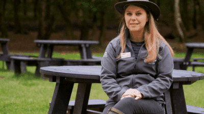 RSBP Sherwood Forest site manager sitting on recycled plastic Calder picnic tables with wheelchair accessibility, purchased to create an inclusive environment and increase footfall by catering to a wider and more diverse audience. Accessibility in outdoor spaces