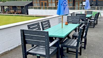 Black Birchcliffe dining set in recycled plastic, set up in a bowling club hospitality area, offering stylish and durable outdoor seating.