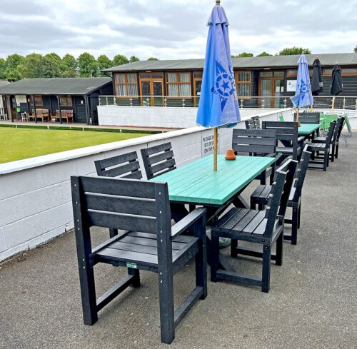 Black Birchcliffe dining set in recycled plastic, set up in a bowling club hospitality area, offering stylish and durable outdoor seating.