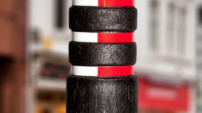 Black round recycled plastic bollard with red and white stripes