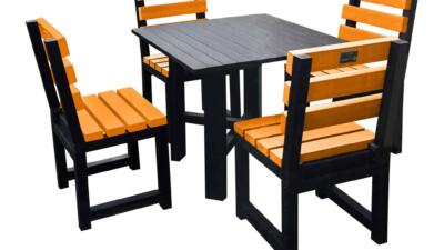 Black square garden table with four orange chairs made from recycled plastic.
