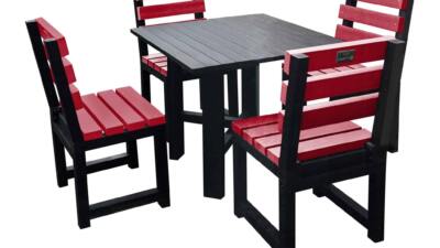 Black square garden table with four red chairs made from recycled plastic.