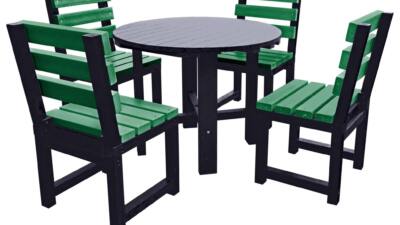 Black round garden table with four green chairs made from recycled plastic.